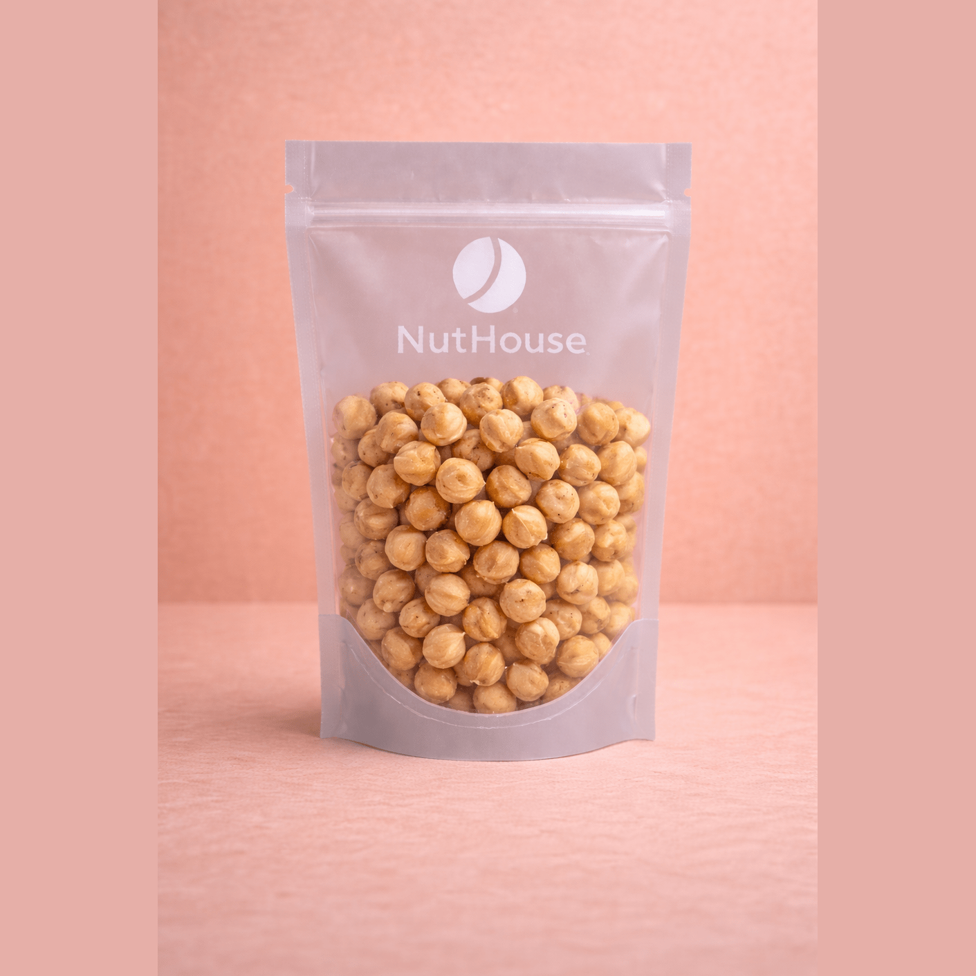 Nut House blanched lightly roasted hazelnuts in silver matte stand-up pouch with resealable top and transparent window showing pale golden-brown skinless nuts