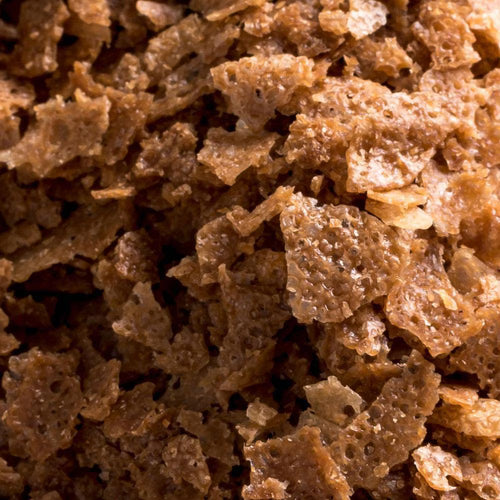 Macro view of golden Cacao Barry crispy caramelised wafer flakes with airy texture