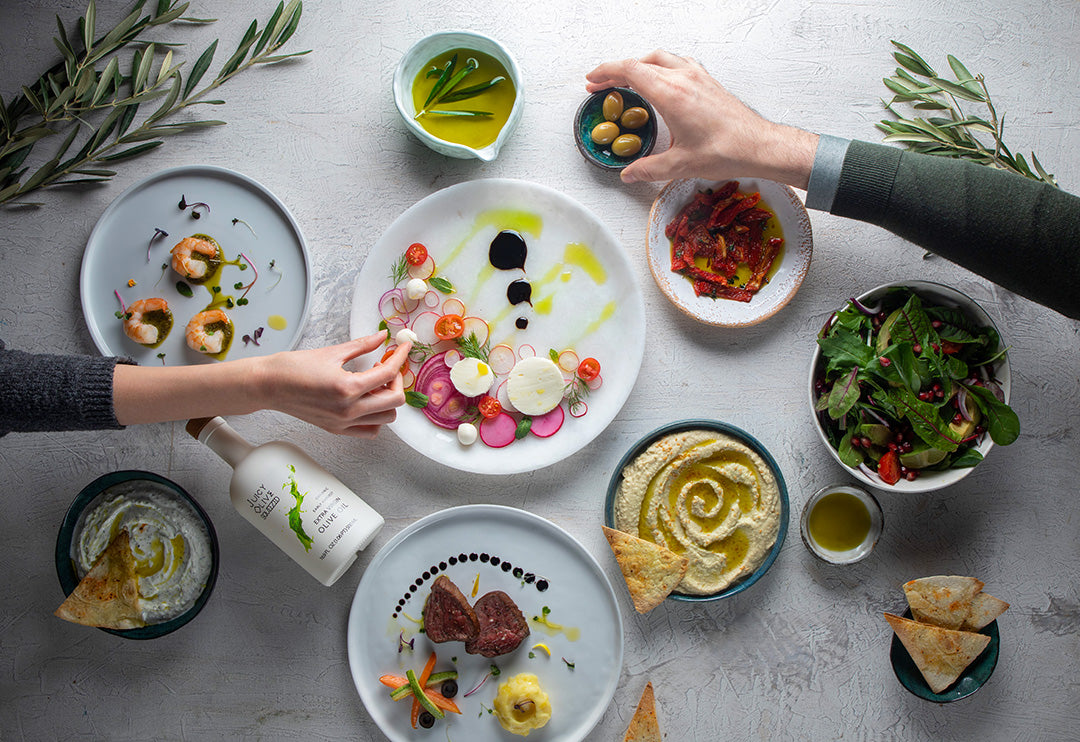 Diverse array of food dishes on a table with people interacting.