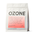 Ozone House Blend coffee beans in white matte resealable pouch with salmon-pink label showing milk chocolate and caramel tasting notes