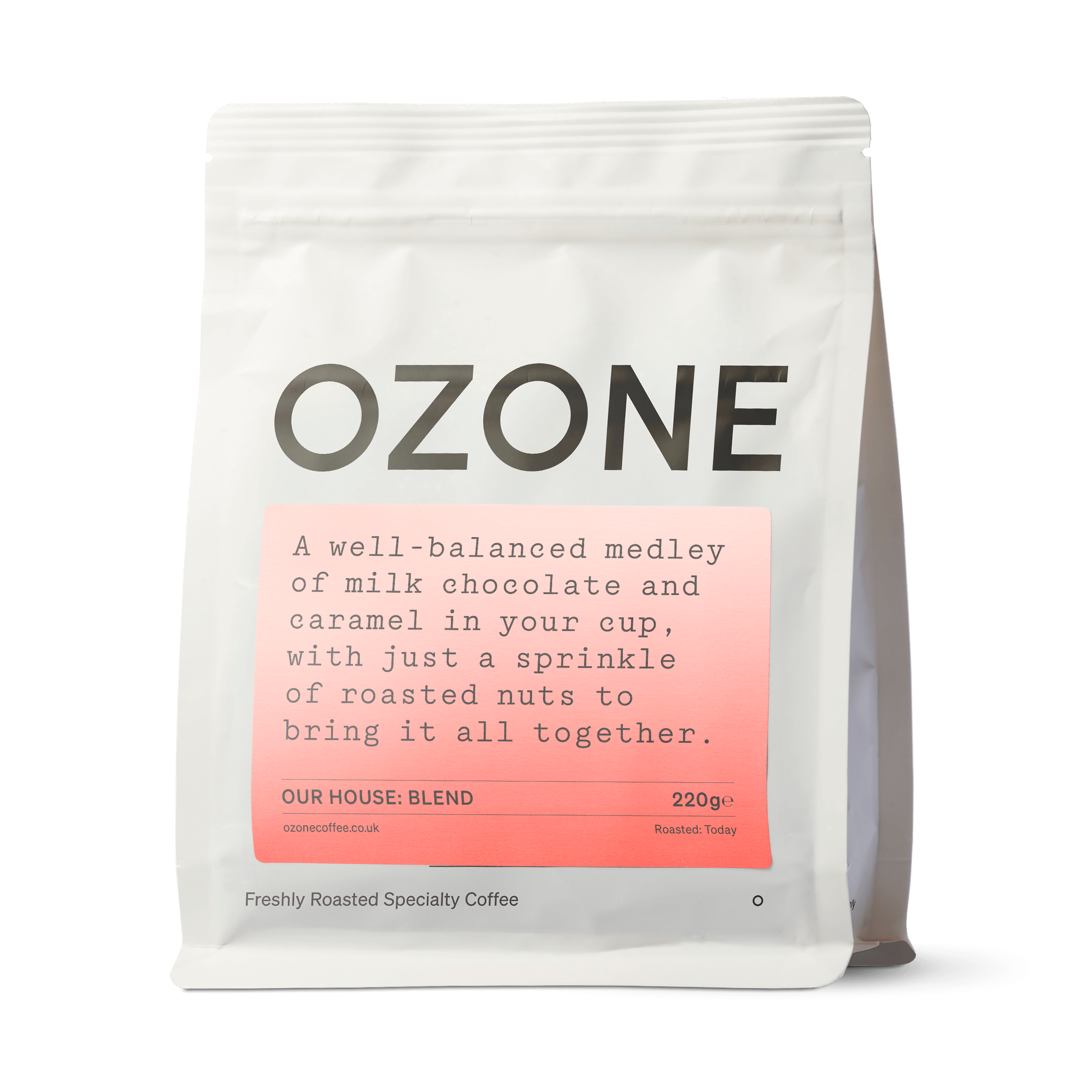 Ozone House Blend coffee beans in white matte resealable pouch with salmon-pink label showing milk chocolate and caramel tasting notes